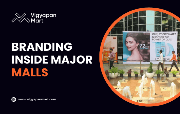 A large mall advertising display shows a woman’s face and a hair product, with fountains and people walking nearby. Text reads Branding Inside Major Malls and includes the Vigyapan Mart logo and website.