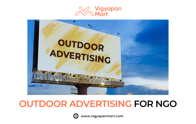 Large roadside billboard with bold text “Outdoor Advertising” against a yellow patterned background. Banner text below reads “Outdoor Advertising for NGO” with Vigyapan Mart branding, highlighting the role of billboard advertising in NGO awareness campaigns.