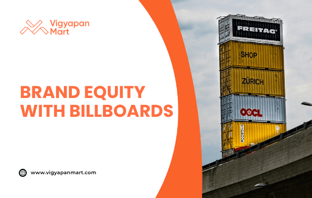 Creative outdoor billboard made of stacked shipping containers featuring brand names including Freitag and OOCL, positioned near a highway. Text overlay reads “Brand Equity with Billboards” with Vigyapan Mart branding, emphasizing innovative billboard advertising for brand visibility.