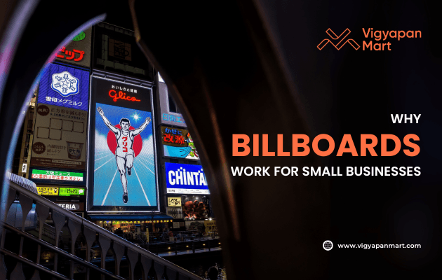 Brightly lit urban area with multiple colorful billboards, including a large one featuring a running athlete. Overlay text reads “Why Billboards Work for Small Businesses” with Vigyapan Mart branding, highlighting the effectiveness of billboard advertising for local brands.
