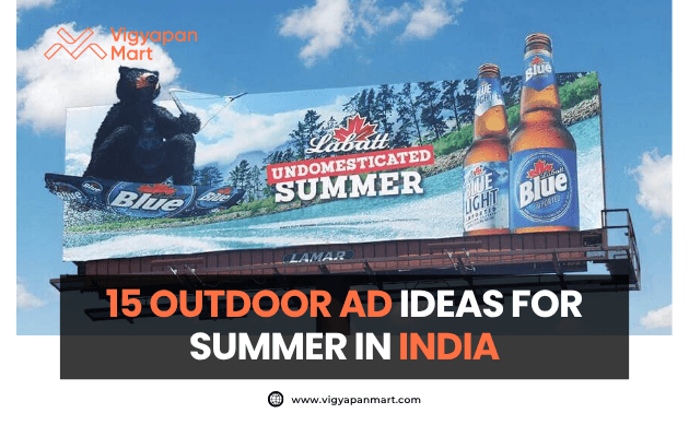 Large outdoor billboard displays a summer-themed beer advertisement featuring Labatt Blue with the slogan “Undomesticated Summer” alongside images of beer bottles and a bear. On the lower part, Vigyapan Mart branding with text “15 Outdoor Ad Ideas for Summer in India” and website www.vigyapanmart.com