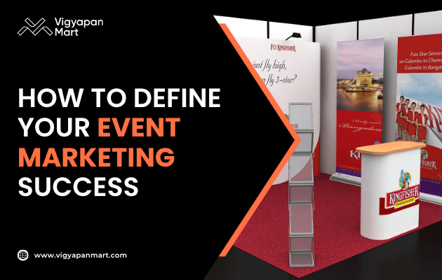 Vigyapan Mart graphic on how to define event marketing success, featuring a trade show booth setup with branded banners, a brochure stand, and a counter on a red carpet floor.