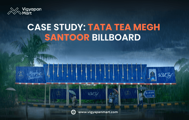 Vigyapan Mart graphic showcasing a creative Tata Tea Megh Santoor outdoor billboard at a bus shelter designed to resemble rainfall, with umbrellas and people standing below. The text reads “Case Study: Tata Tea Megh Santoor Billboard.” Vigyapan Mart logo and website are shown.