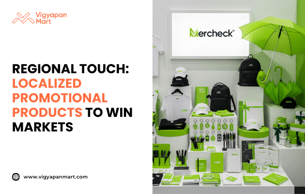 Display of localized promotional products including branded t-shirts, caps, backpacks, umbrellas, pens, mugs, and stationery in green and white color theme with 'Mercheck' branding. Marketing banner text reads 'Regional Touch: Localized Promotional Products to Win Markets' by Vigyapan Mart, emphasizing customized merchandise for market reach.