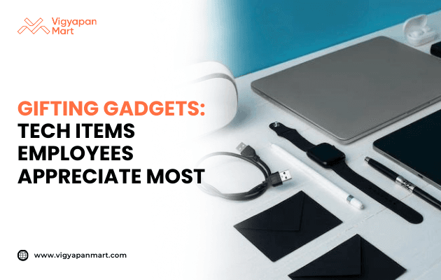 Flat lay of modern tech gifting gadgets including smartwatch, wireless earbuds, charging cable, stylus pen, laptop, and accessories on white background. Marketing banner text reads 'Gifting Gadgets: Tech Items Employees Appreciate Most' by Vigyapan Mart, showcasing popular employee gift ideas.