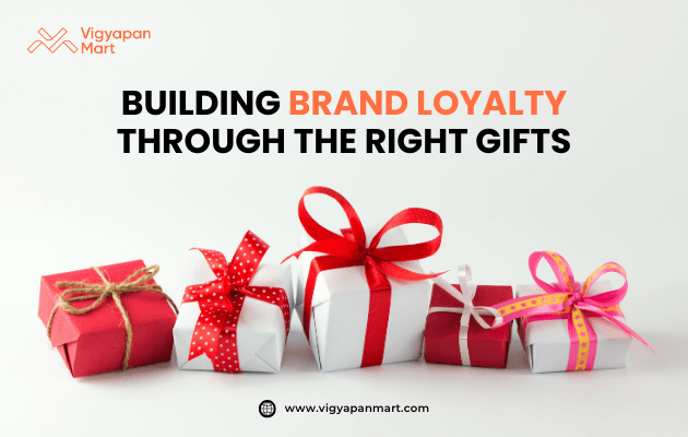 Row of colorful gift boxes wrapped in red, white, and pink paper with decorative ribbons, placed on white background. Marketing banner text reads 'Building Brand Loyalty Through the Right Gifts' by Vigyapan Mart, highlighting the role of gifting in customer retention and brand growth.