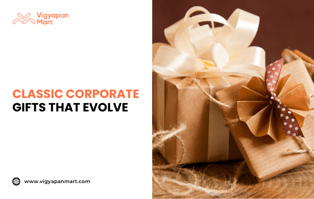 Elegant corporate gift wrapped in brown kraft paper with ivory satin ribbon bow, placed on rustic wooden surface with jute accents. Marketing banner text reads 'Classic Corporate Gifts That Evolve' by Vigyapan Mart, highlighting timeless yet modern business gifting ideas.