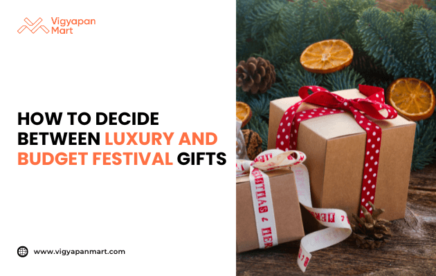 Gift boxes wrapped in brown paper with red and white ribbons, surrounded by pine branches, pinecones, and dried orange slices, with text: How to decide between luxury and budget festival gifts. Vigyapan Mart branding and website shown.