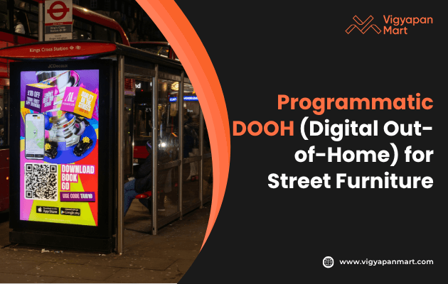 Digital out-of-home (DOOH) advertising display at a city bus stop near King’s Cross Station at night, showcasing a colorful illuminated digital screen promoting a mobile app download with QR code. The ad example represents programmatic DOOH for street furniture advertising. Branding for Vigyapan Mart is visible on the right with their logo and website URL www.vigyapanmart.com