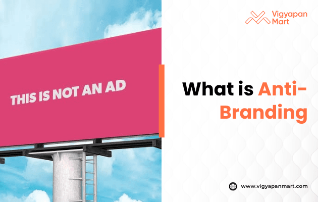 A pink billboard against a blue sky reads "THIS IS NOT AN AD," alongside text asking, "What is Anti-Branding?" and the Vigyapan Mart logo.