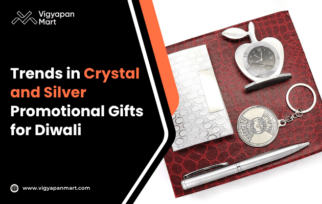 A red textured box with a crystal apple clock, a keychain, a pen, and an envelope. Text reads 'Trends in Crystal and Silver Promotional Gifts for Diwali.