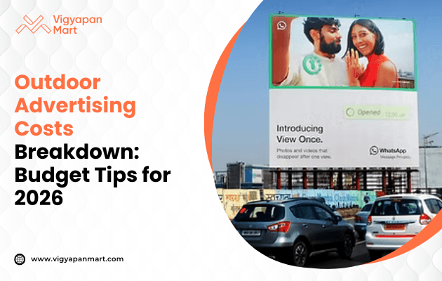 A prominent street billboard features a WhatsApp advertisement showing a happy couple under a clear sky, along with text about outdoor advertising costs and budget tips for 2026, branded by Vigyapan Mart.