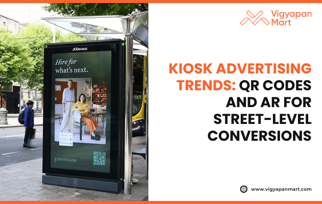City street kiosk with an ad featuring a man and woman in business attire, promoting hiring with a QR code. Caption highlights kiosk advertising trends.