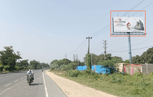 Unipole billboard with a real estate advertisement on a highway, visible to passing commuters and truck traffic
